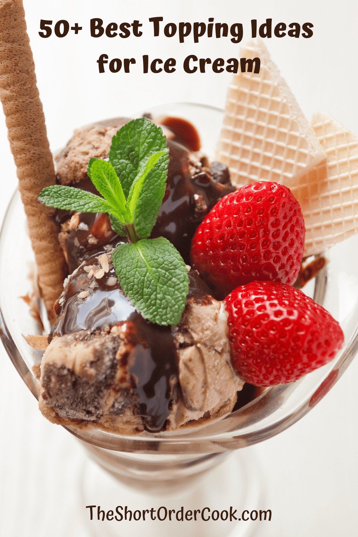 Chocolate ice cream topped with fruit, wafer cookie, and fresh mint.