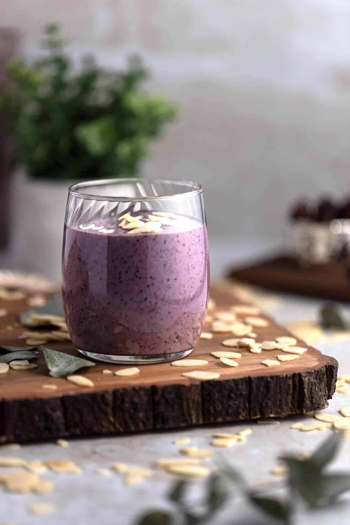 A short glass filled with purple blueberry smoothie.