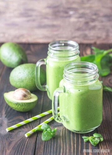 Two glass mugs filled with green smoothies.