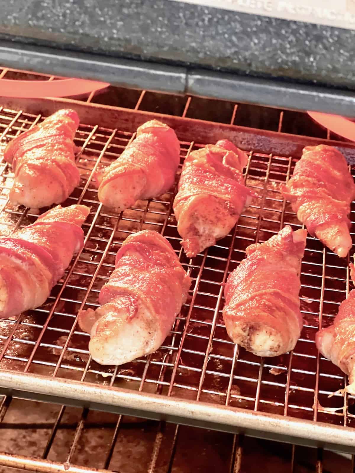 A tray of chicken under the broiler to make bacon crispy.