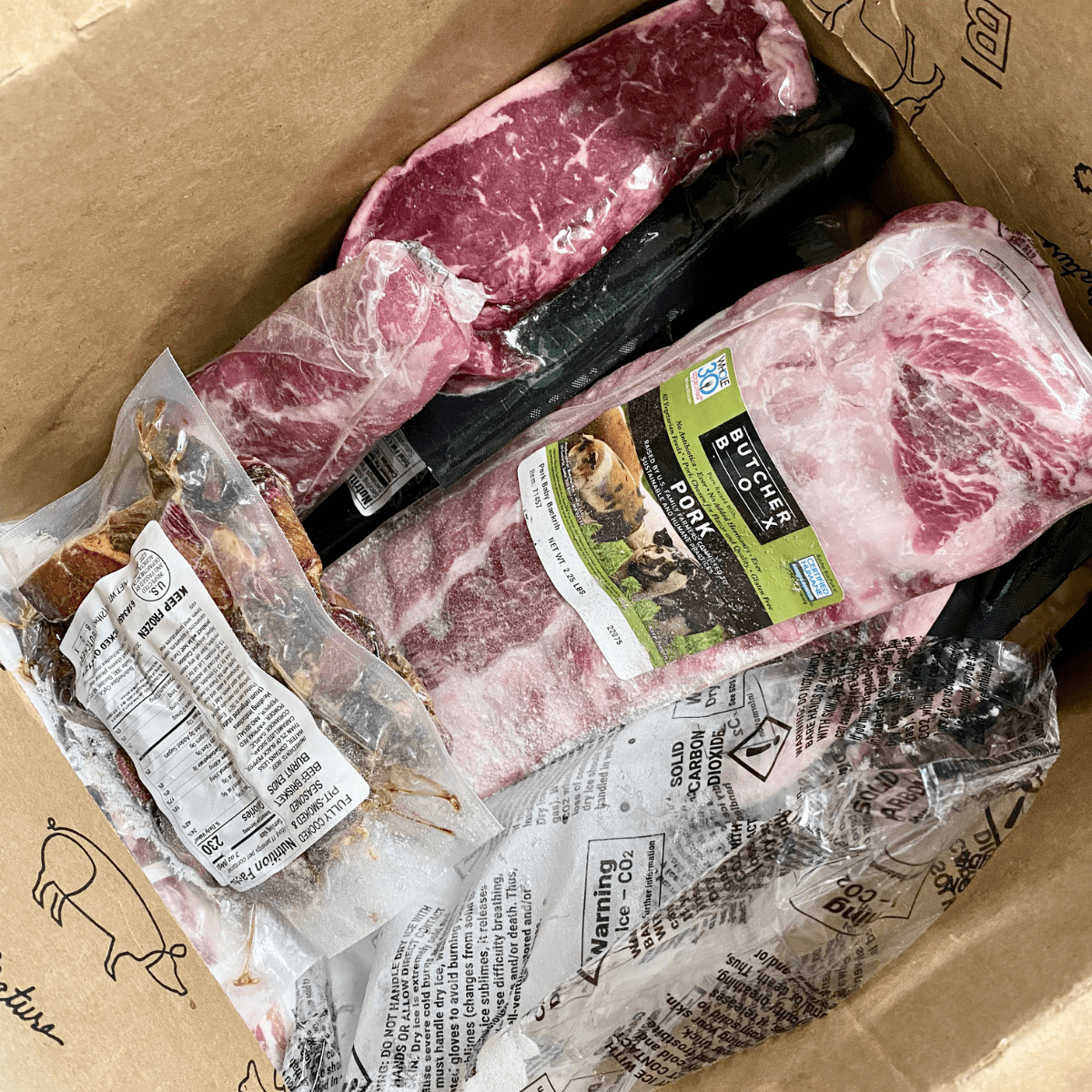 Inside the ButcherBox delivery box with frozen sealed packages of meat.