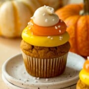 Pumpkin cupcake with layered frosting in the color of candy corn.