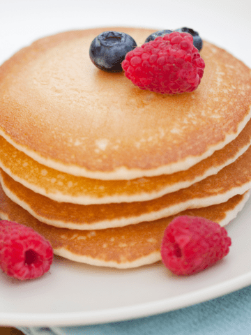 Stack of pancakes topped with fresh berries.