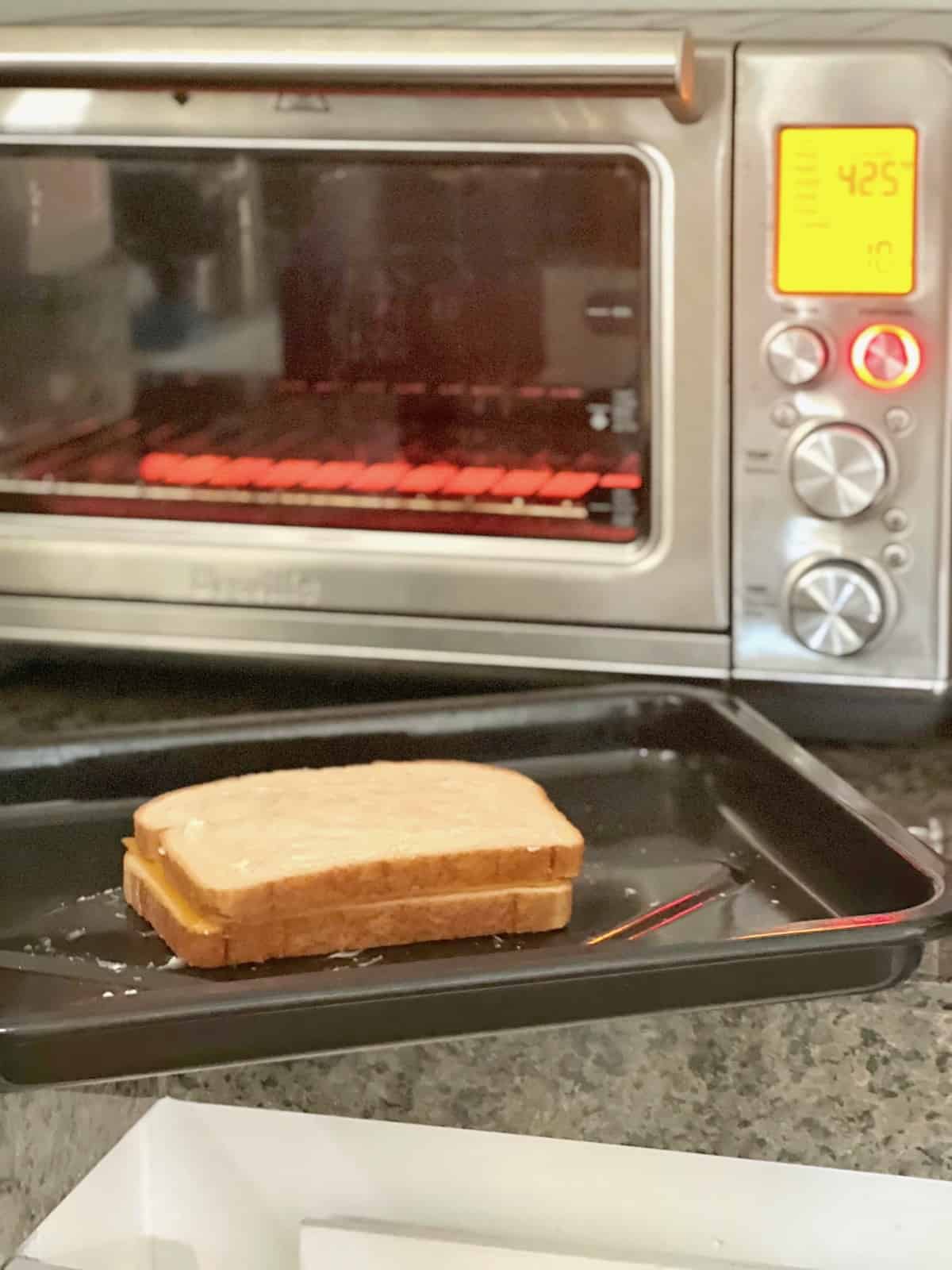 Assembled grilled cheese on a tray waiting for toaster oven to preheat.