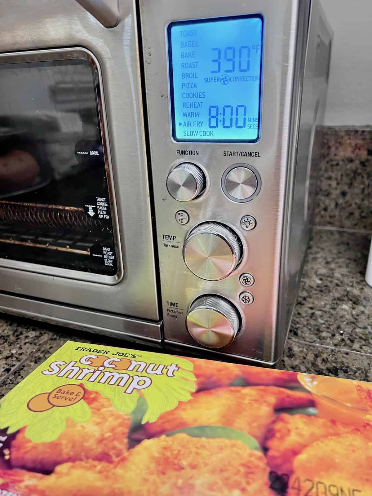 Air Fryer Frozen Coconut Shrimp Box and the air fryer set for time and temperature.