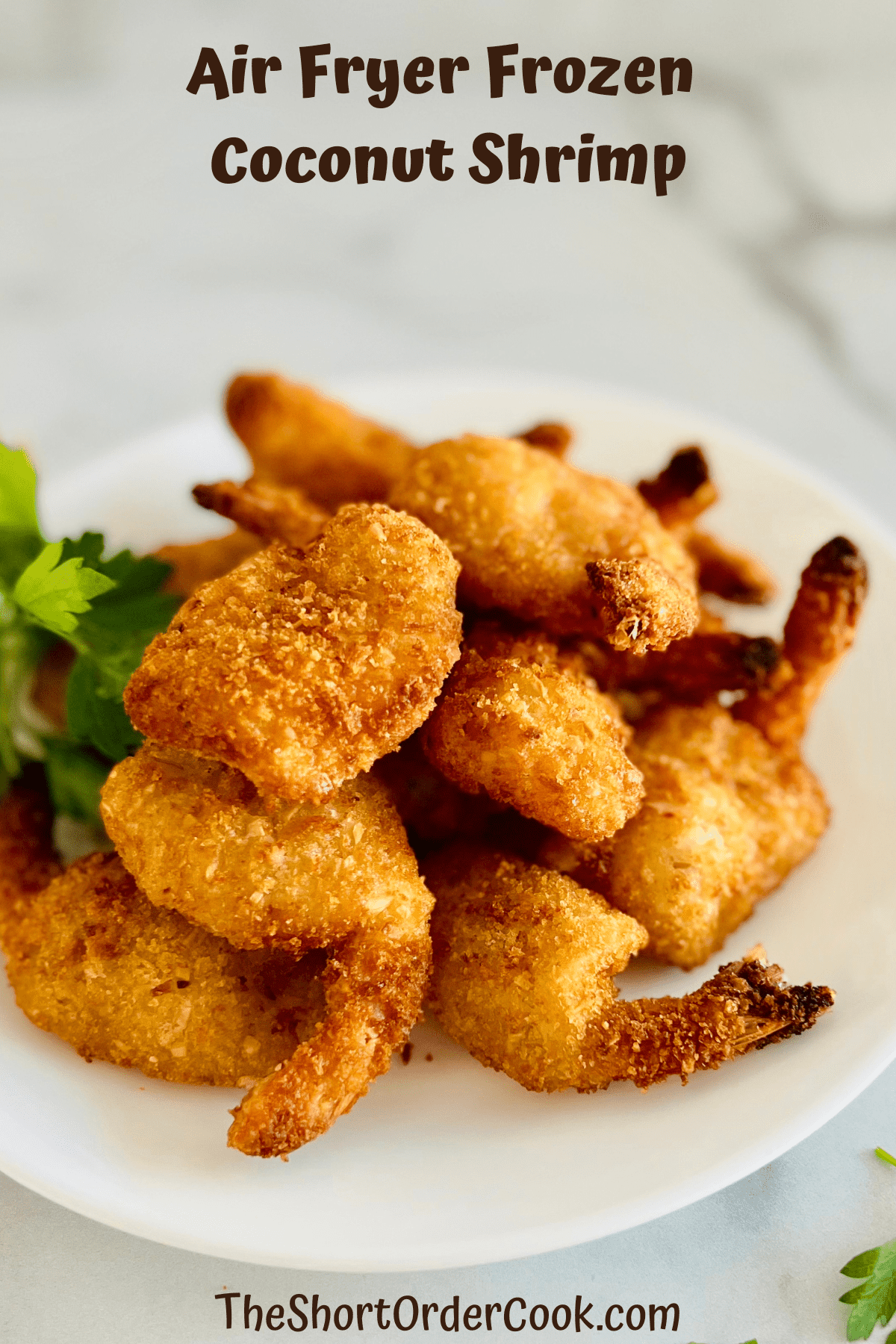 White plate piled with air fried coconut shrimp