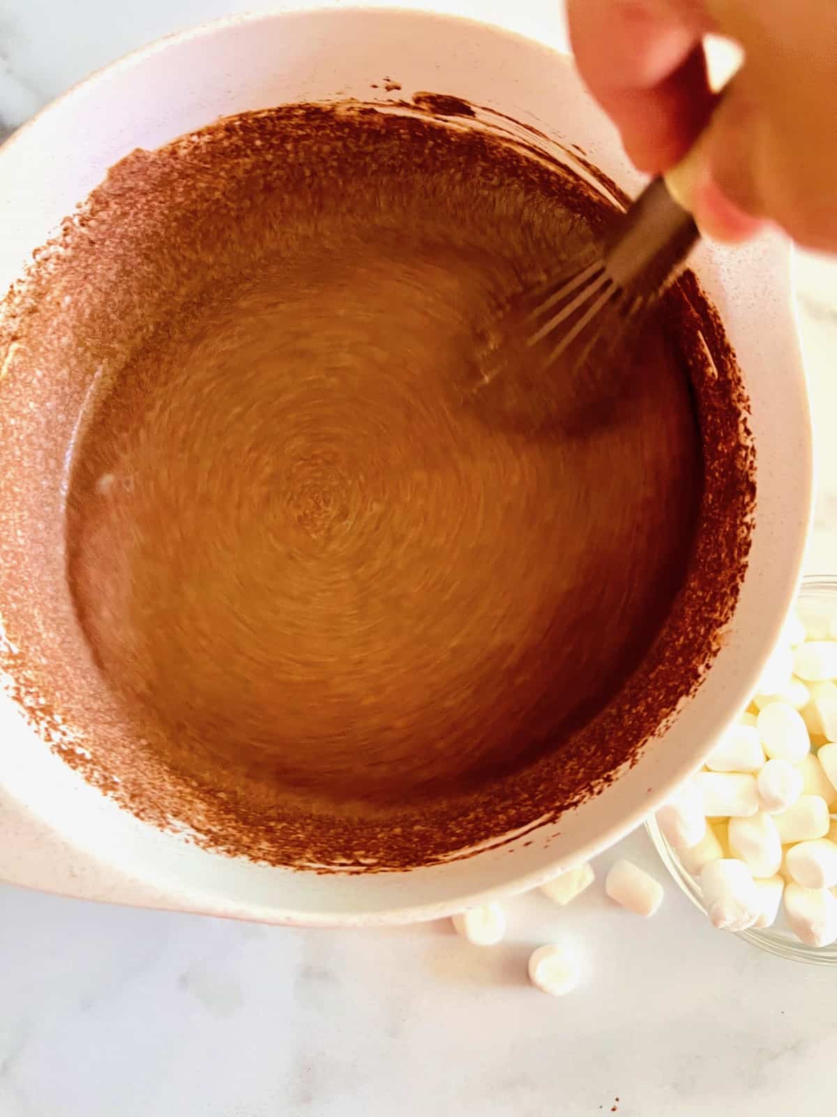 Whisking cocoa into the milk sugar and cream base