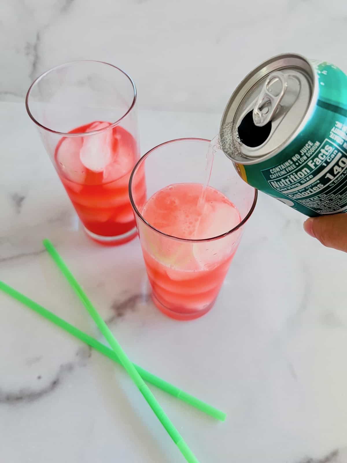 Hocus Pocus Kid-Friendly Punch Adding soda to the punch in the drinking glasses with ice.