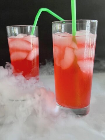 Hocus Pocus Kid-Friendly Punch on a table with dry ice fog swirling around.