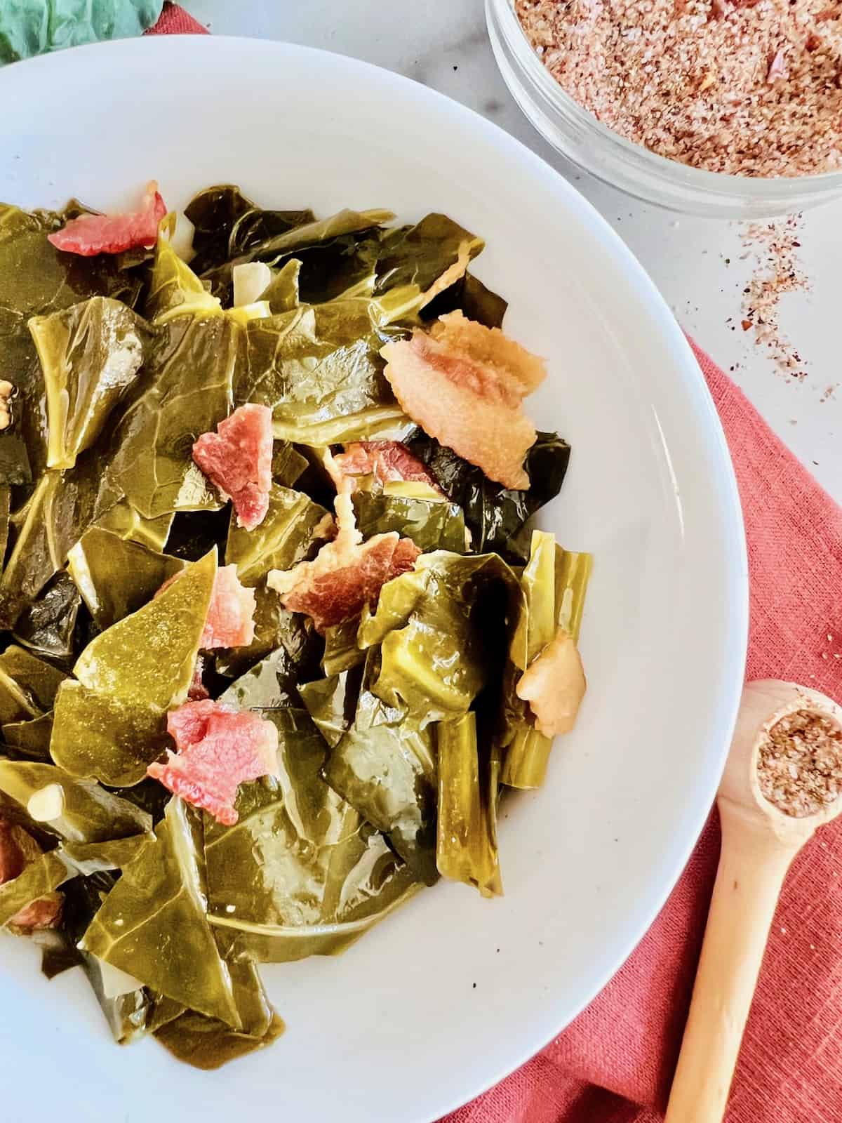 Partial closeup of bowl filled with cooked collard greens.