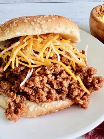 A bun topped with 3-ingredient sloppy joe meat and cheese.