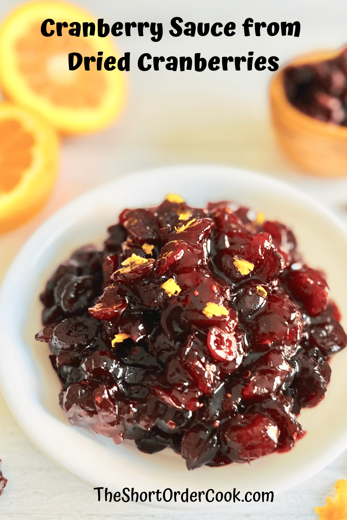 White bowl filled with homemade cranberry sauce with orange zest.