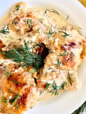 Chicken thighs in a creamy lemon sauce with fresh sprigs of dill.