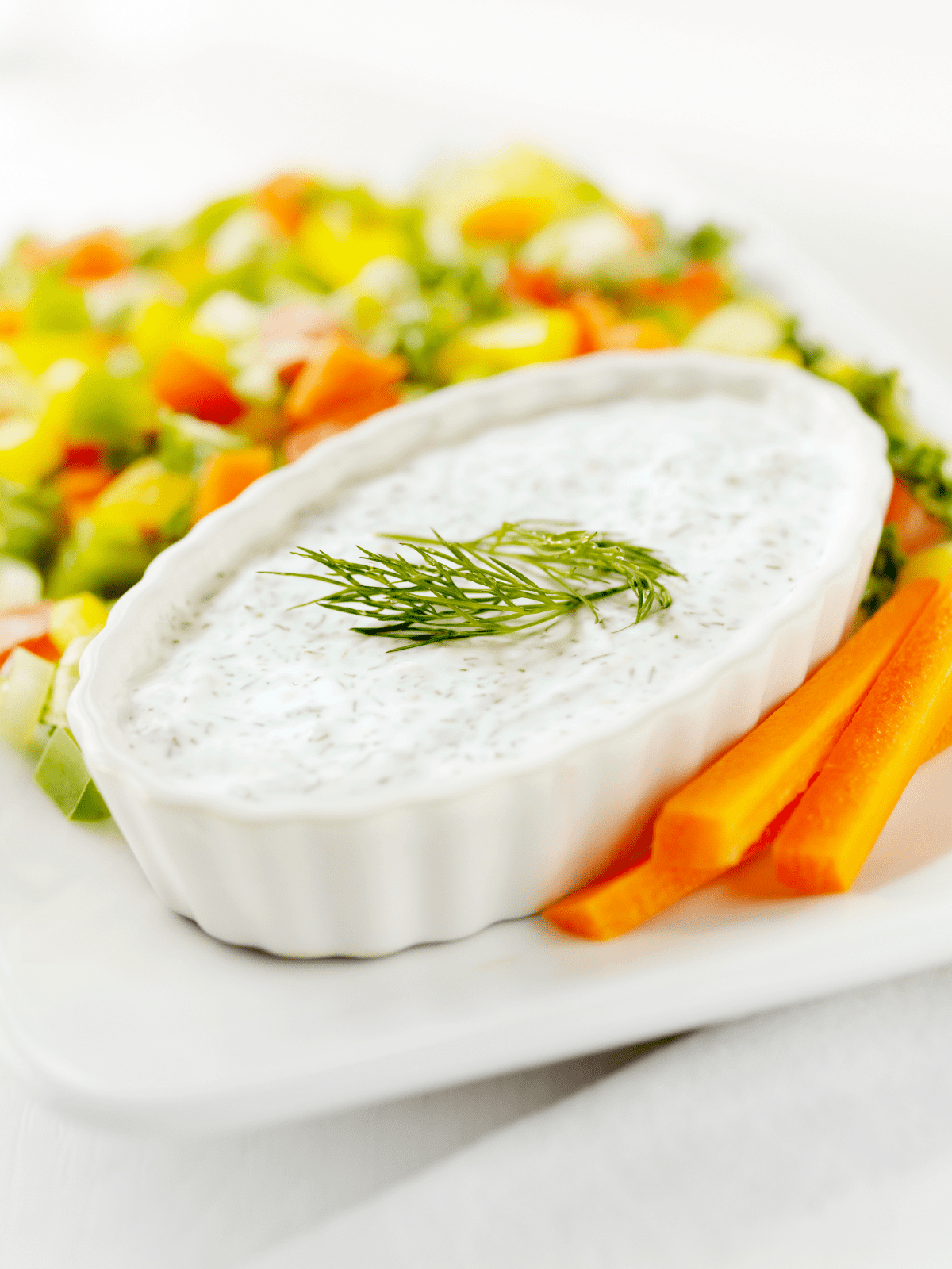 Dill dip and raw vegetables on a platter.
