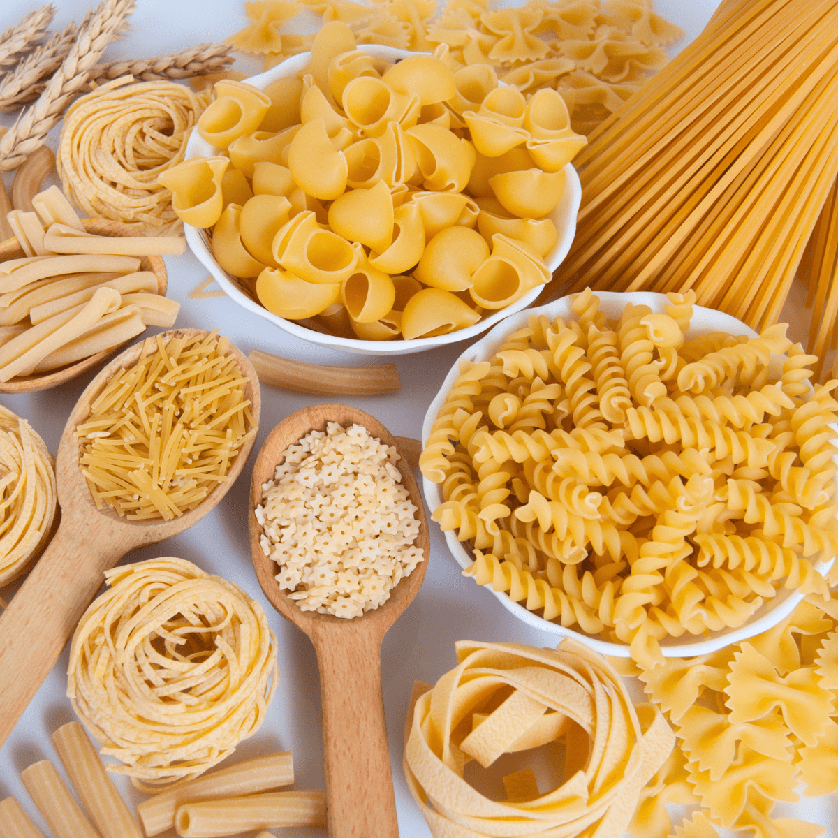 A table with many different dry pasta shapes on it.