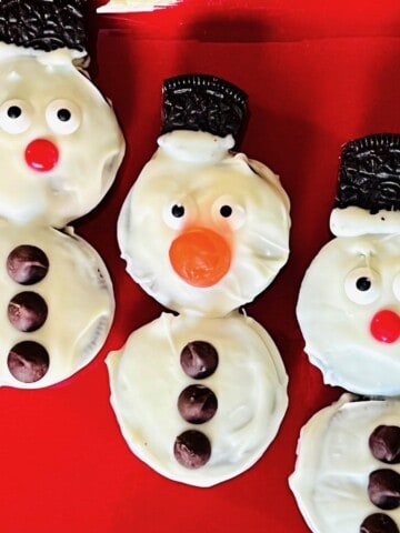 3 Snowman cookies with gumdrop noses and candy eyes.