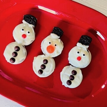 Snowman oreo cookies decorated and ready to eat on a platter.