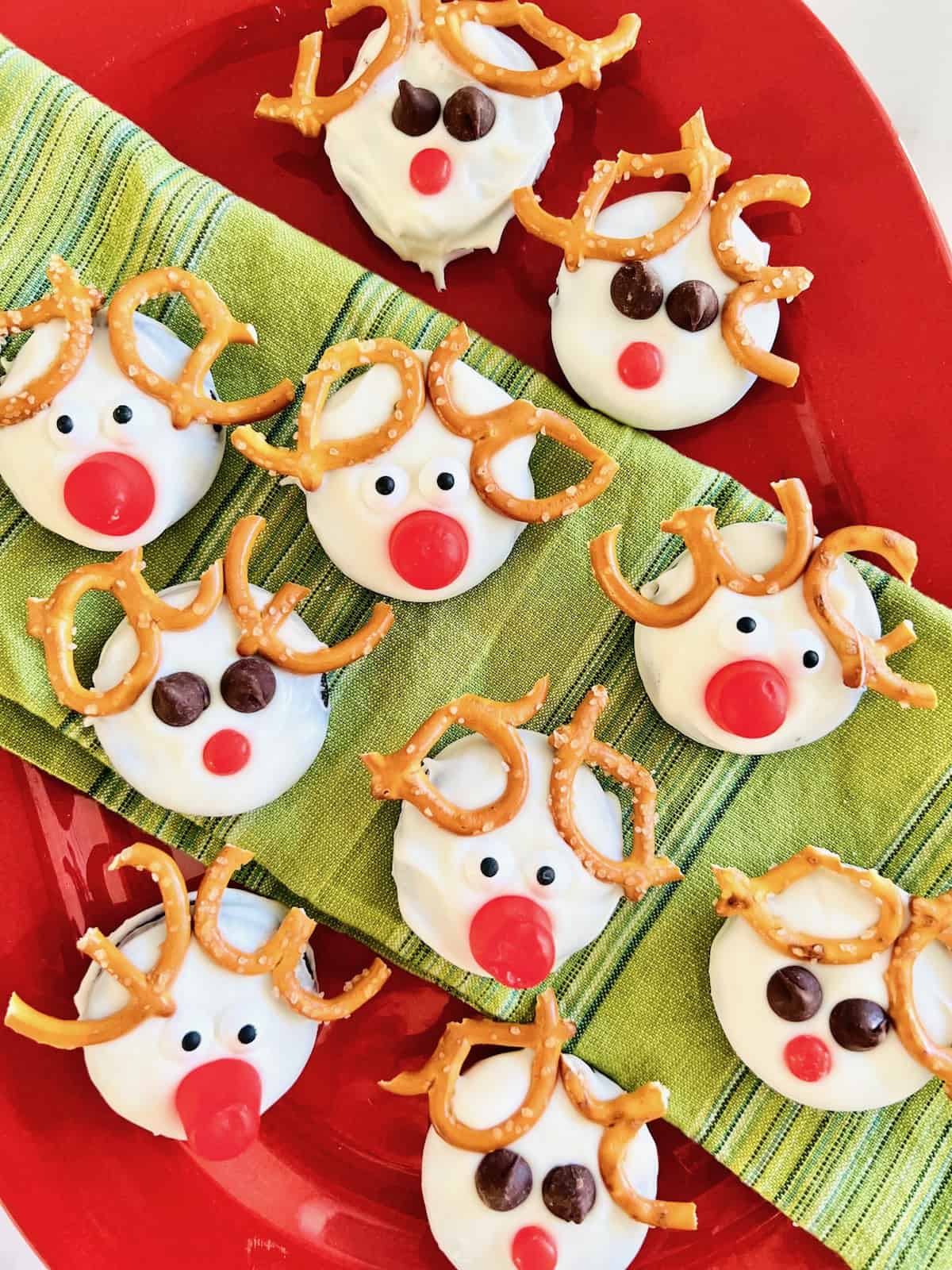 Green napkin over a red Christmas platter displaying Oreo Rudolph cookies.