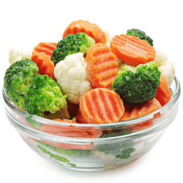 A glass bowl filled with steamed frozen vegetable mix.
