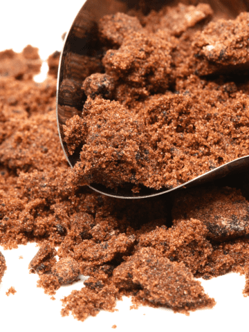 Muscovado sugar in a pile on a white table.