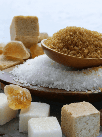 Different sugar cubes and grains in spoons.