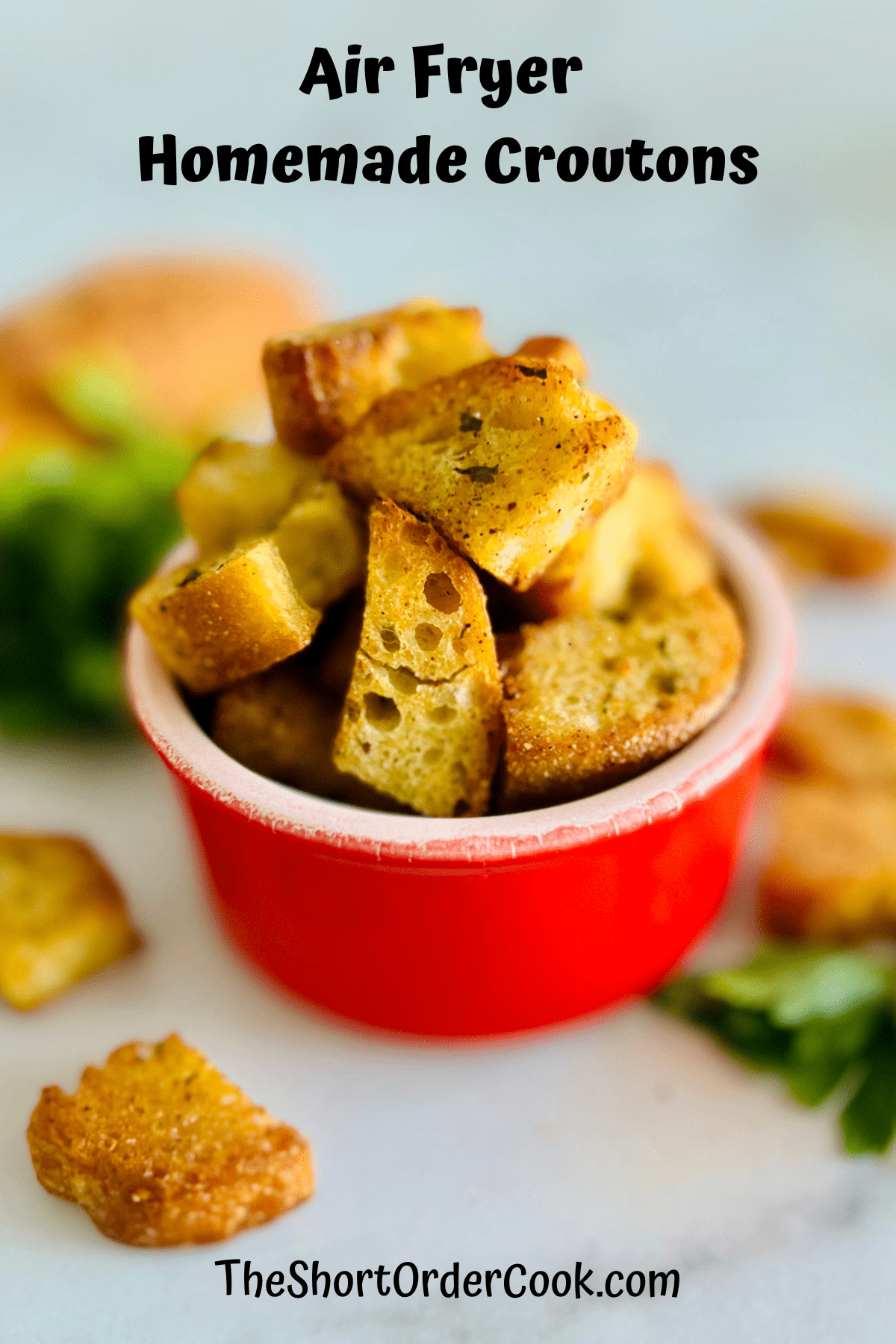 Crispy crunchy croutons that were cooked in the air fryer in a red bowl.