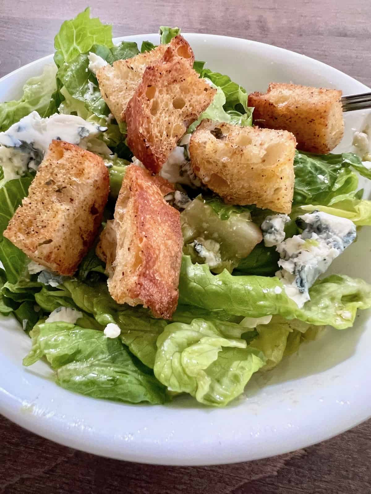 Air Fryer Homemade Croutons as a topping on a green salad in a bowl.