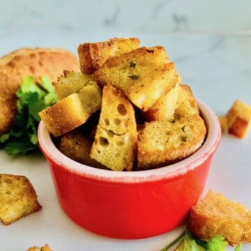 Air fried garlic croutons in a red bowl.