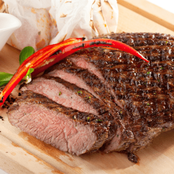 Cutting board with sliced flank steak.