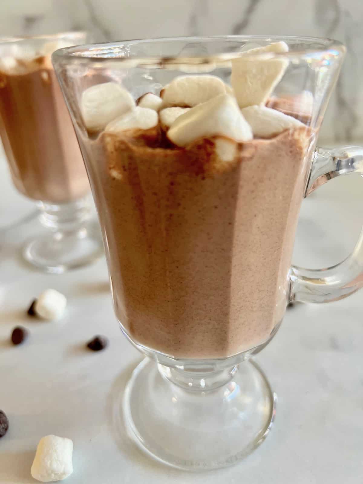 Best Hot Chocolate with Chocolate Chips two glasses filled with homemade stovetop hot chocolate topped with mini marshmallows.