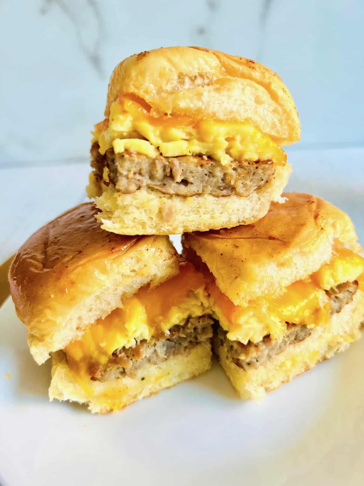 Hawaiian Roll Breakfast Sliders Closeup 3 stacked on a plate ready to eat.