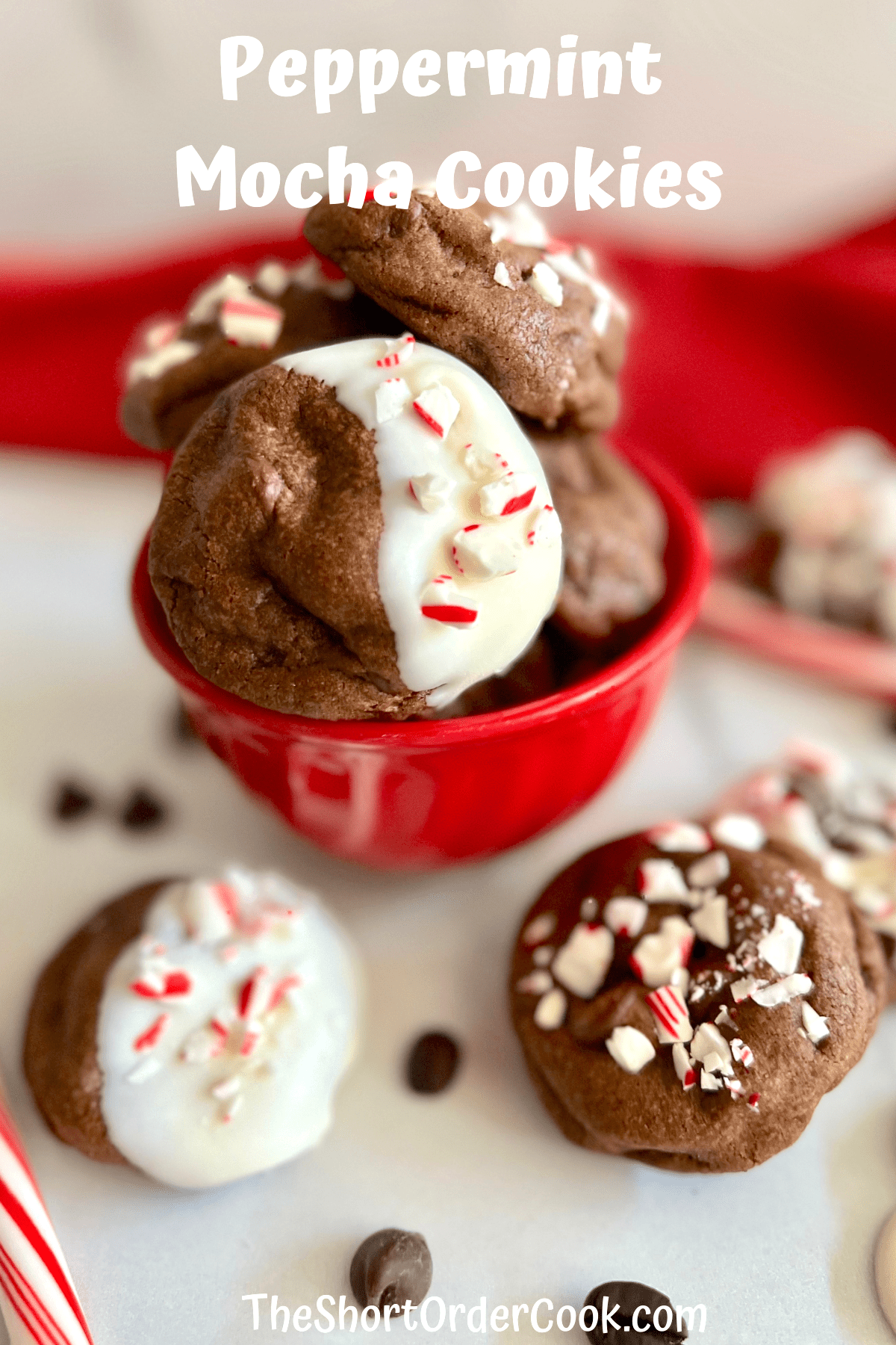 Red bowl with peppermint mocha cookies and other cookies and candy canes to the side.
