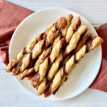 Plate of cinnamon twist made with puff pastry.