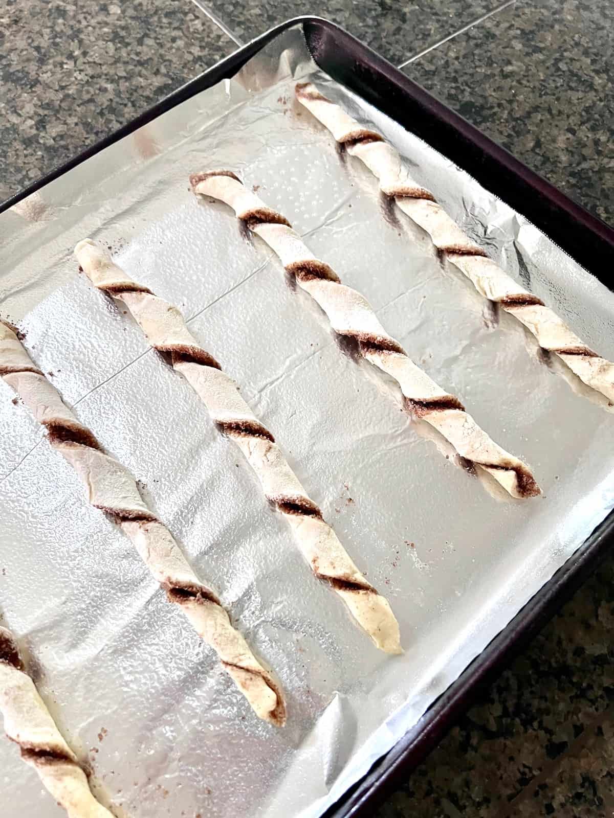 Puff Pastry Cinnamon Twists Twisted on the lined baking sheet ready to bake.