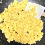 Scrambled eggs softly cooked in a skillet.