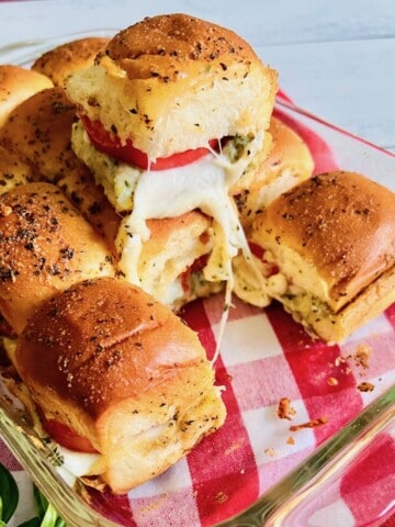 Caprese sliders with melted mozzarella, tomatoes, and pesto.