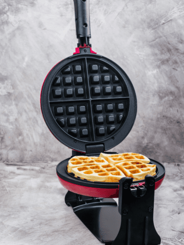 Flip wffle maker on the counter with a waffle done cooking in it.
