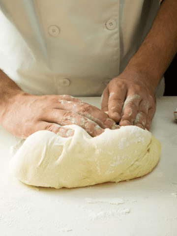 Kneading pizza dough on the counter.