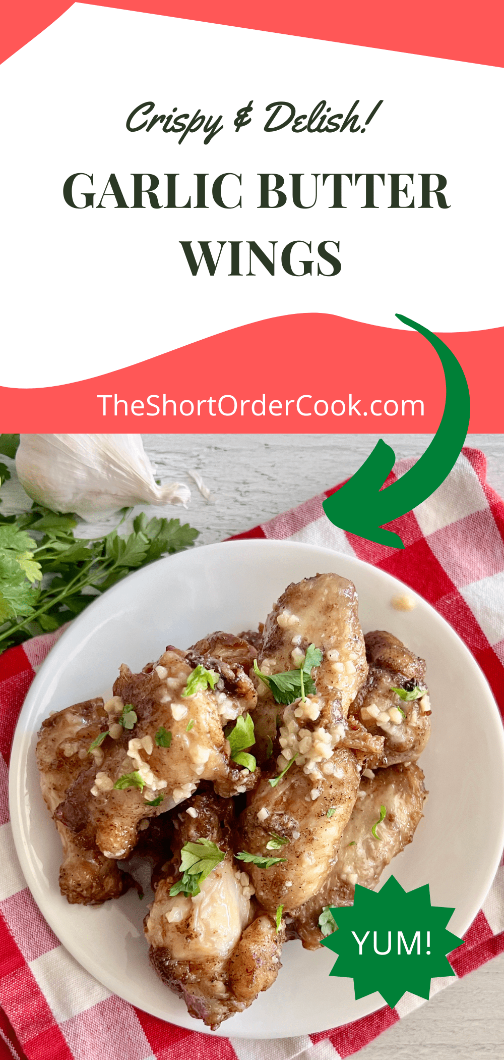 Garlic Butter chicken wings on a plate topped with fresh garlic and parsley leaves.