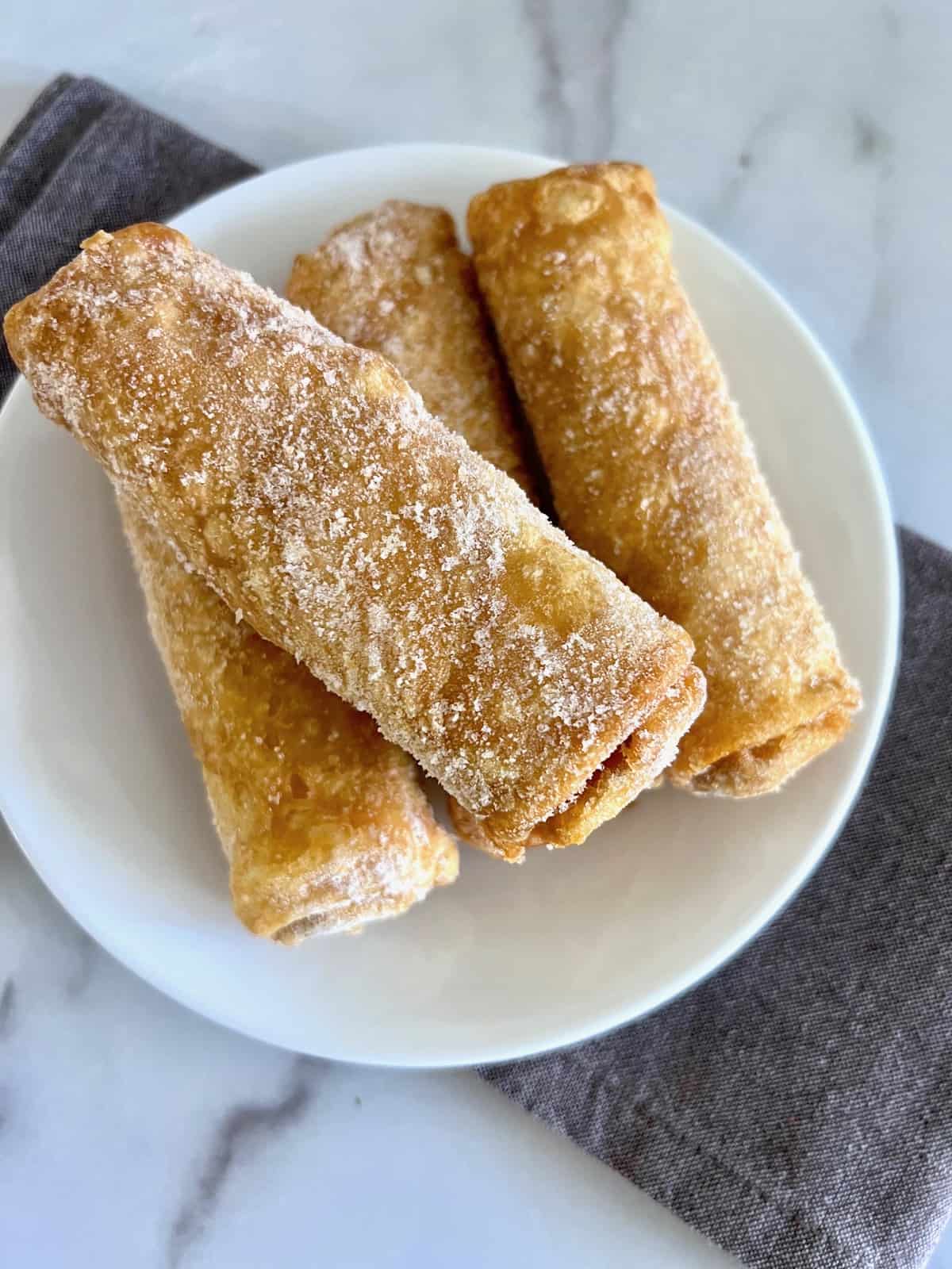 Frozen Egg Rolls Frozen from the freezer on a plate waiting for air fryer to preheat.