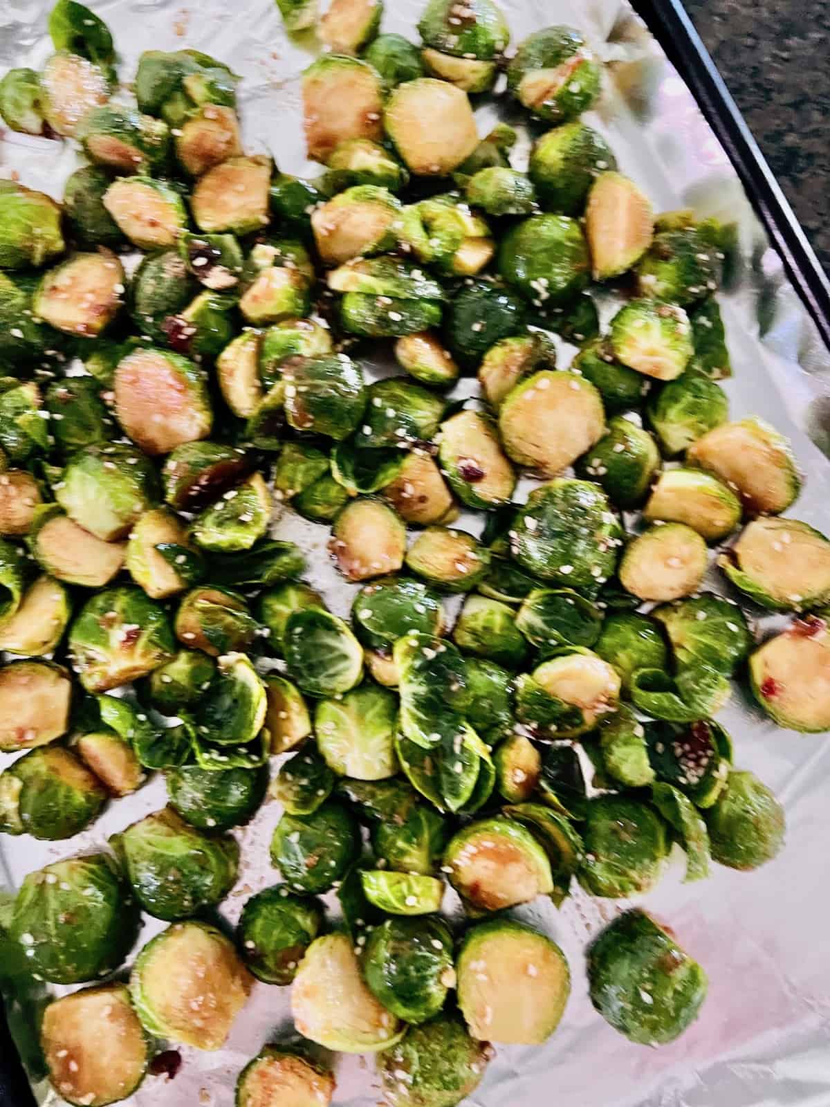 Asian-Inspired Teriyaki Brussels Sprouts On a sheet pan ready to go in the oven.
