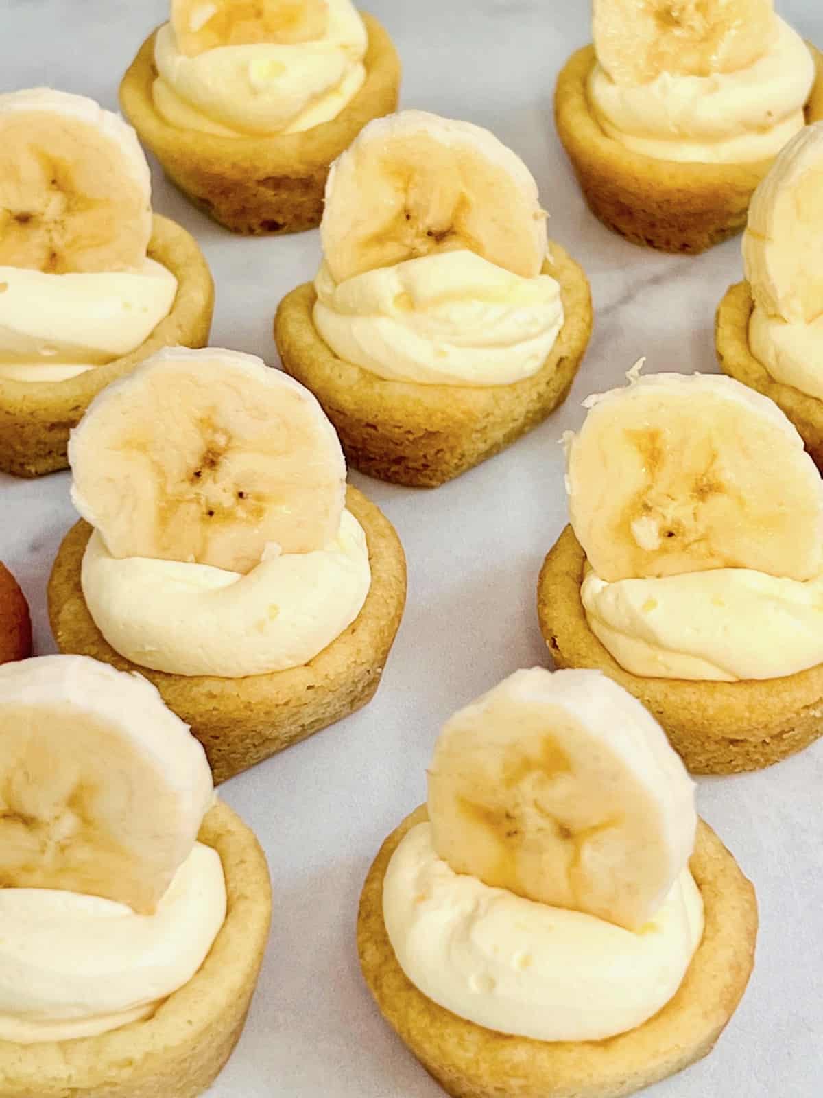 Banana Cream Pie Cookie Cups Closeup of banana topped cookie cups lined up.