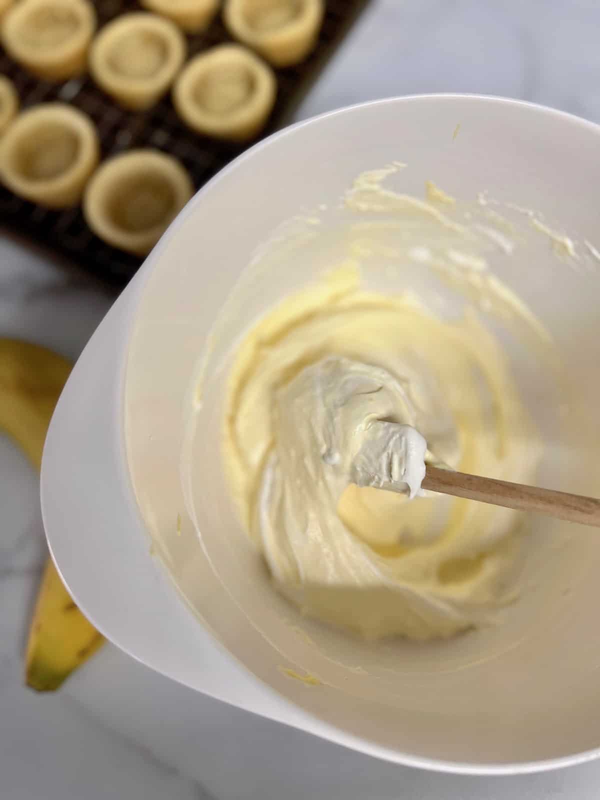 Folding in the cool whip to the banana pudding mix.