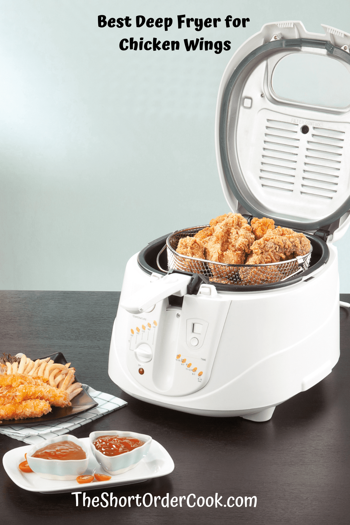 Deep fryer with lid open and fried chicken inside.