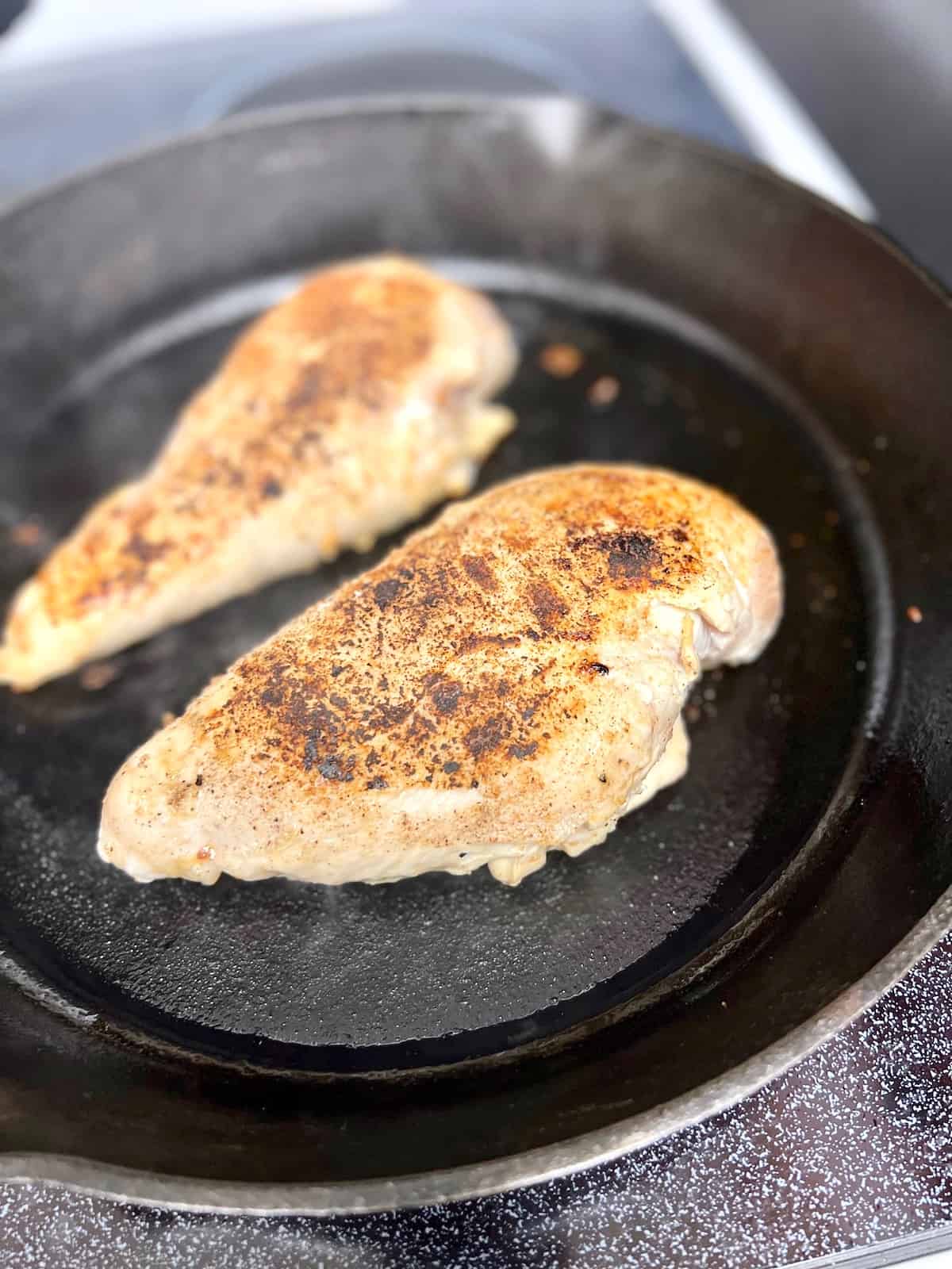 Cast Iron Chicken Breast Cooking the other side in the skillet.