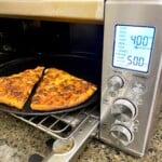 Pizza in toaster oven hot and ready to eat.