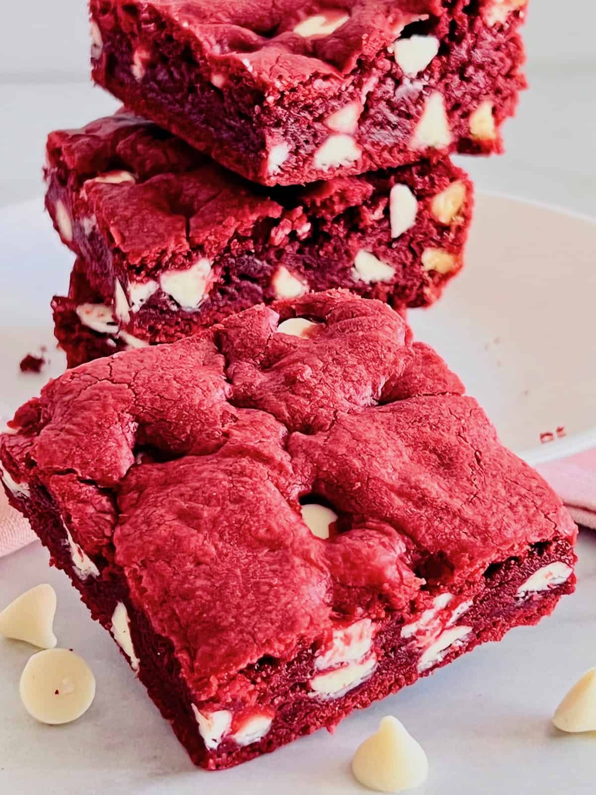 Red Velvet Brownies with Cake Mix 3 stacked on a plate and one in front.