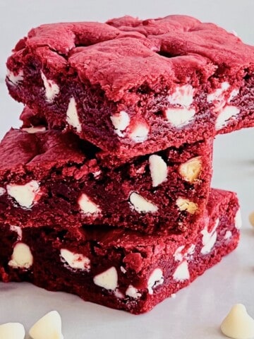 Red Velvet Brownies with Cake Mix cut in squares on a counter with white chocolate chips.