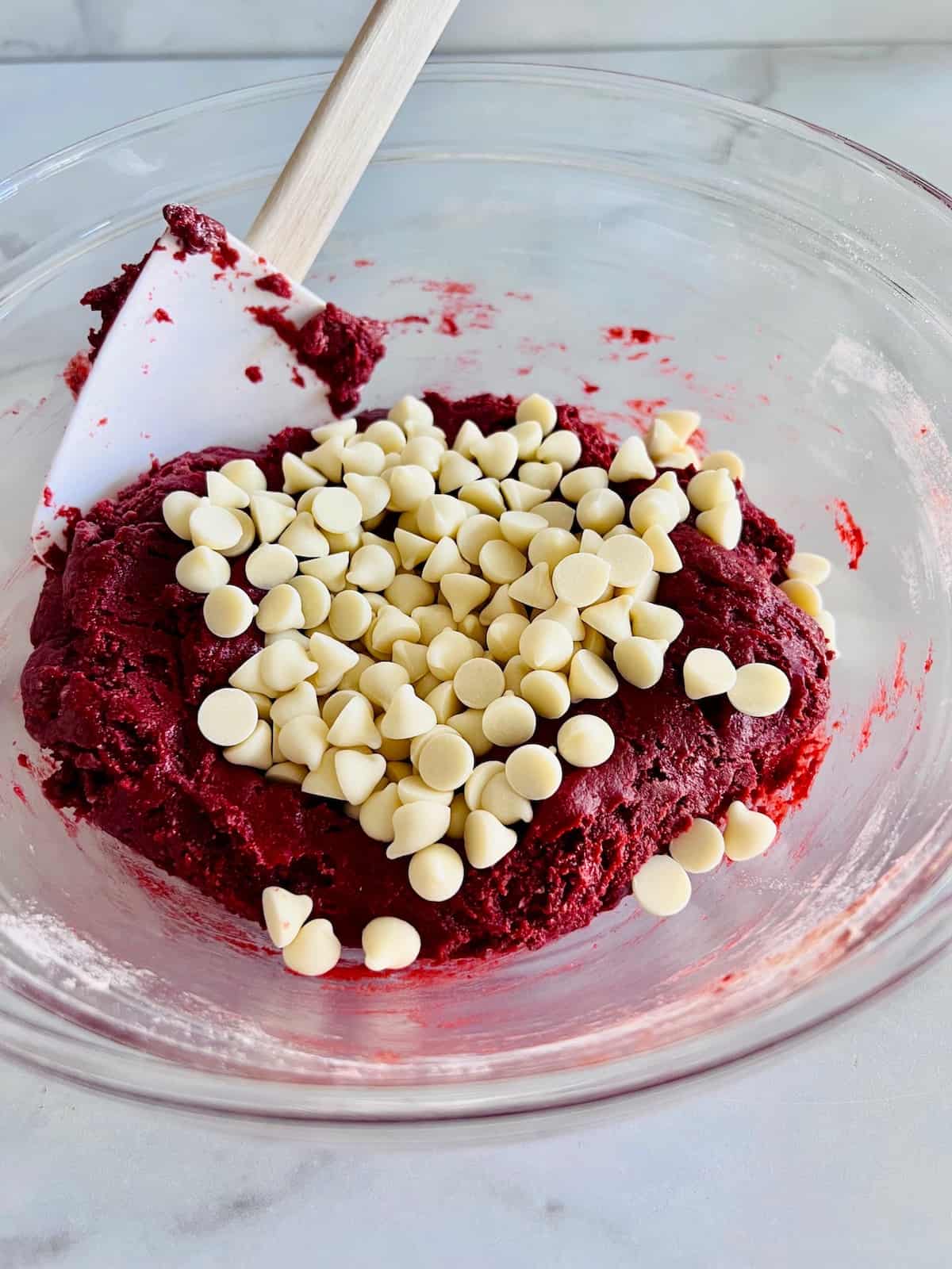 Folding in the white chocolate chips into the red velvet brownie batter.