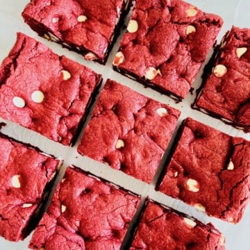 Red Velvet Brownies with Cake Mix cut into 9 squares on parchment paper.